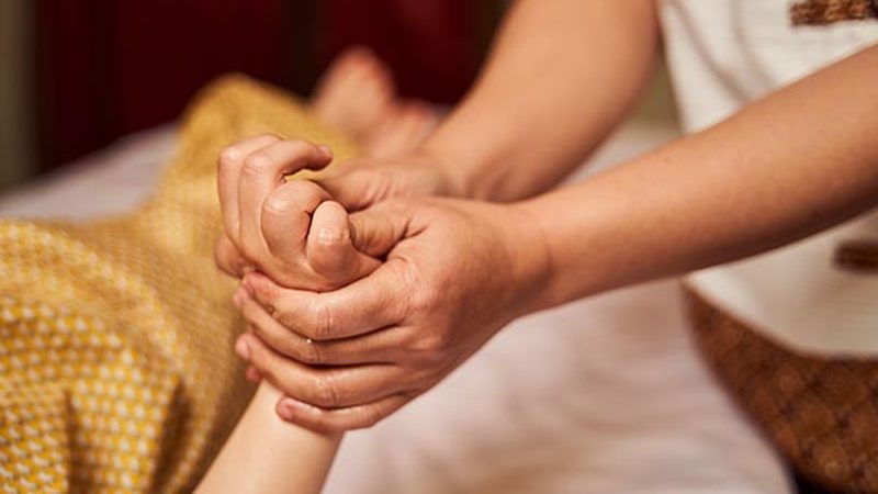 Massage therapist working on a patient hand and forearm